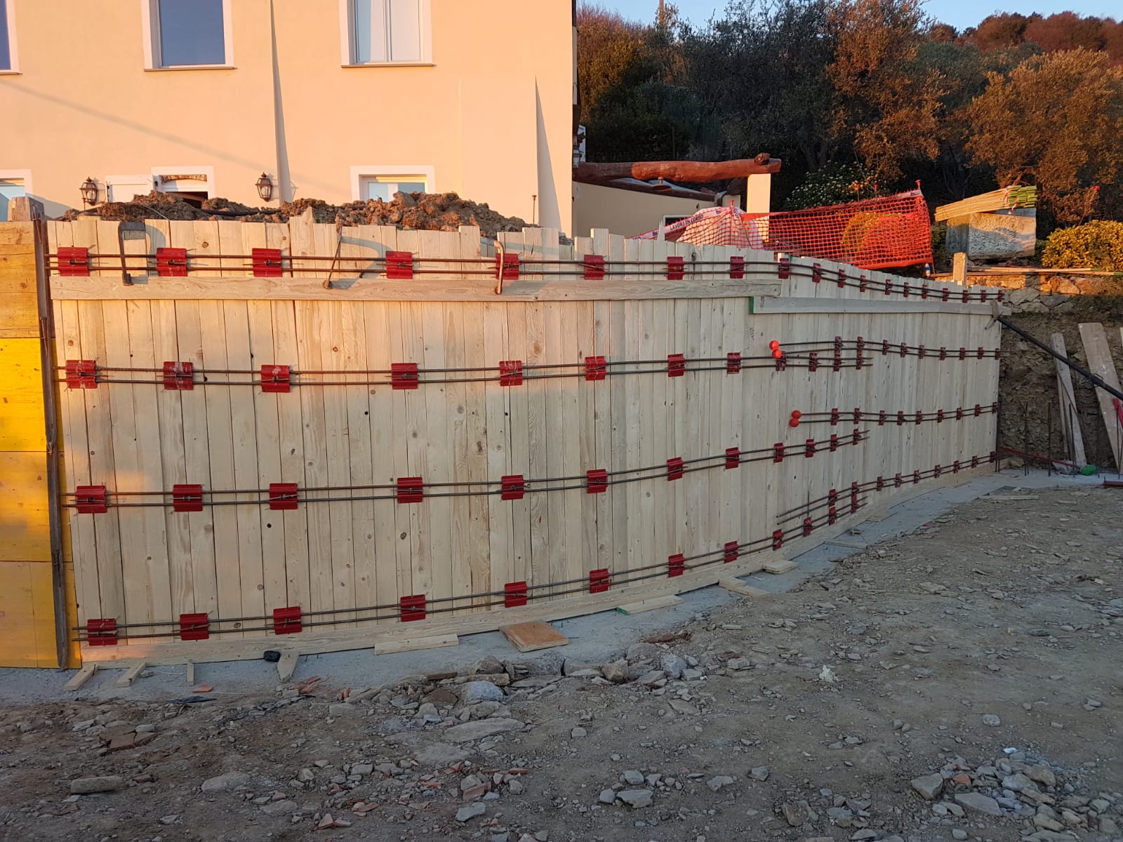 11. Completamento dei casseformi in legno non a perdere per il muro di contenimento curvo: lavori in corso.